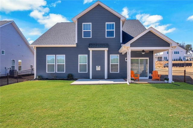 rear view of property featuring a patio, a yard, a ceiling fan, and fence