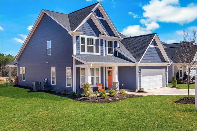 craftsman house featuring cooling unit, fence, concrete driveway, a front lawn, and a garage