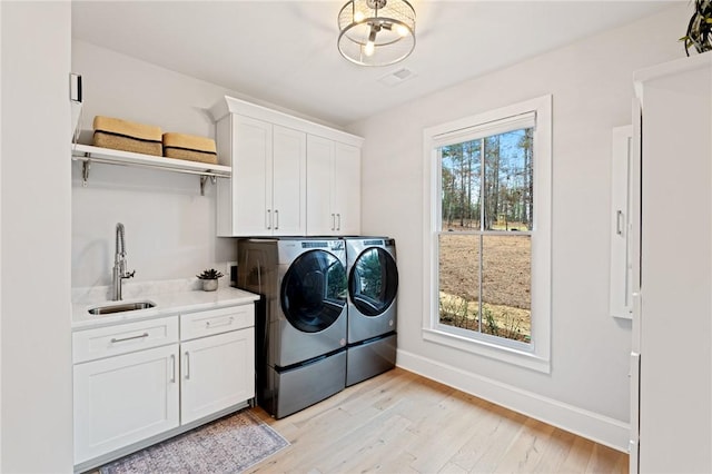 505 Bellhaven Ct, Salem, SC 29676 - washroom with light wood finished floors, baseboards, washer and clothes dryer, cabinet space, and a sink
