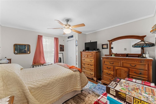 bedroom with visible vents, wood finished floors, a ceiling fan, and crown molding