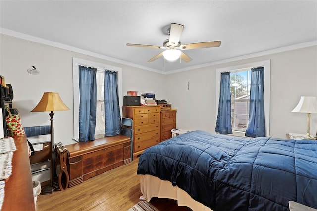 bedroom featuring a ceiling fan, light wood finished floors, and ornamental molding