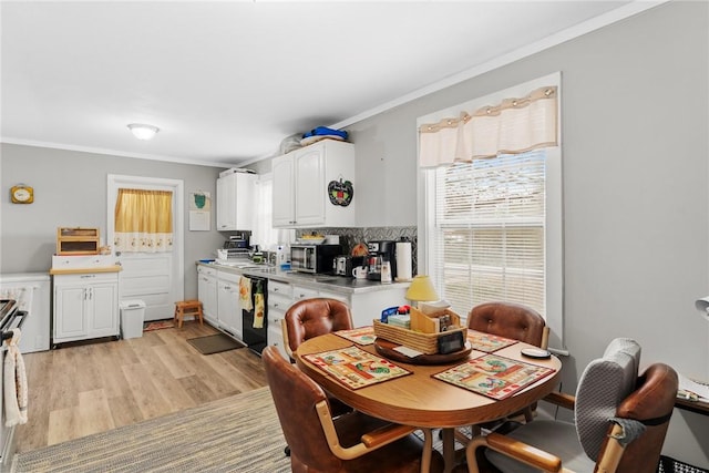 dining room featuring light wood-style flooring and ornamental molding