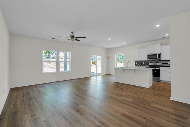 kitchen featuring dark wood-style flooring, open floor plan, white cabinetry, a ceiling fan, and appliances with stainless steel finishes