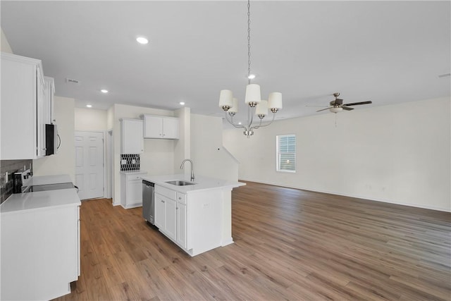 kitchen featuring appliances with stainless steel finishes, a sink, white cabinetry, open floor plan, and light wood-type flooring