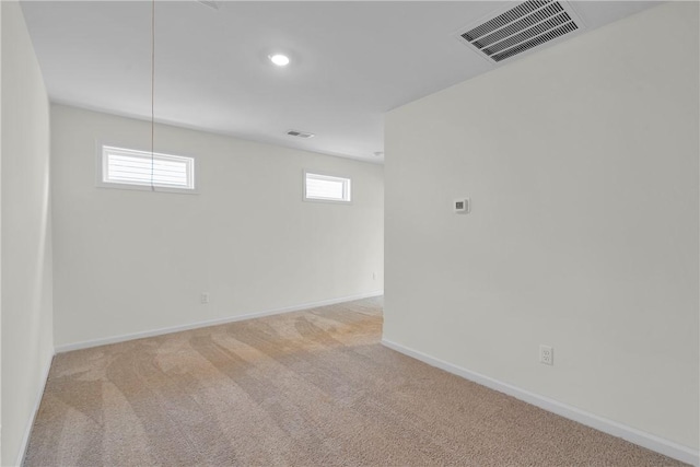 basement with visible vents, carpet, and baseboards