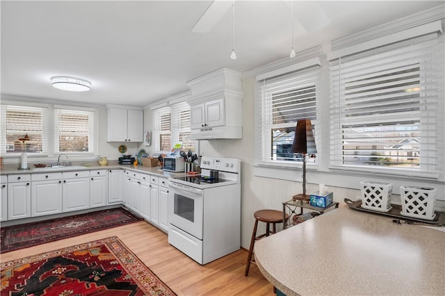 kitchen featuring under cabinet range hood, a sink, white electric stove, white cabinets, and light wood finished floors