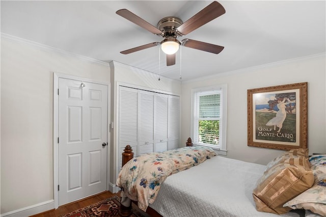 bedroom featuring a closet, crown molding, baseboards, and wood finished floors