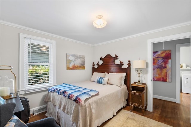 bedroom with baseboards, washer / clothes dryer, wood finished floors, and crown molding