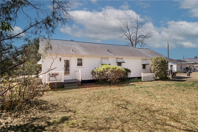 back of house with central AC unit and a lawn