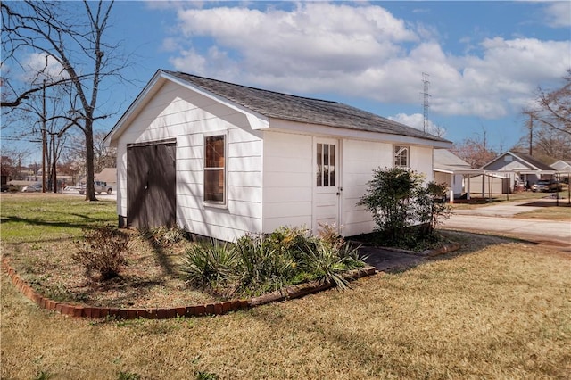 view of side of home with an outbuilding and a lawn