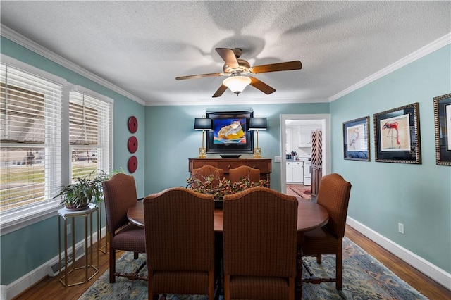 dining area featuring crown molding, wood finished floors, baseboards, and a textured ceiling