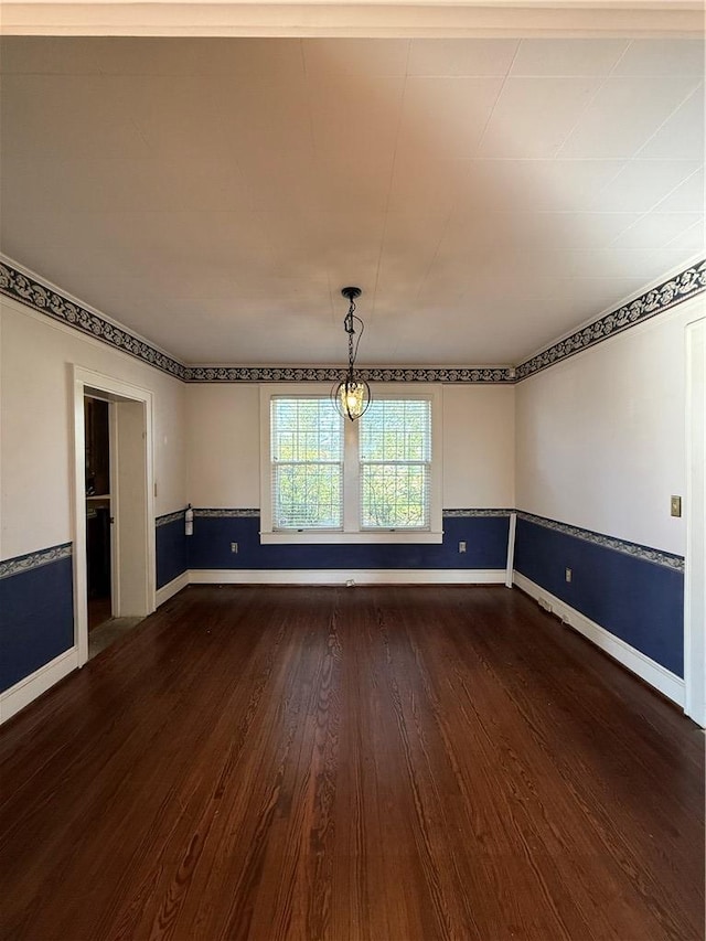 empty room featuring baseboards and dark wood-style flooring