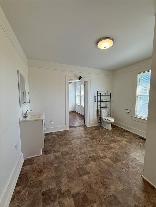 bathroom featuring a sink, baseboards, and toilet