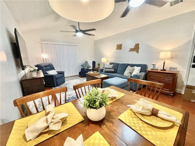 dining area featuring lofted ceiling, wood finished floors, visible vents, and ceiling fan