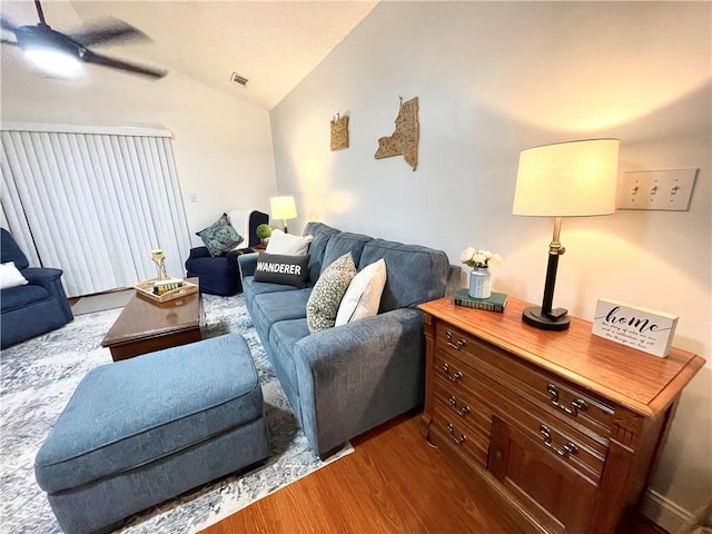 living room with dark wood-style floors, visible vents, ceiling fan, and lofted ceiling