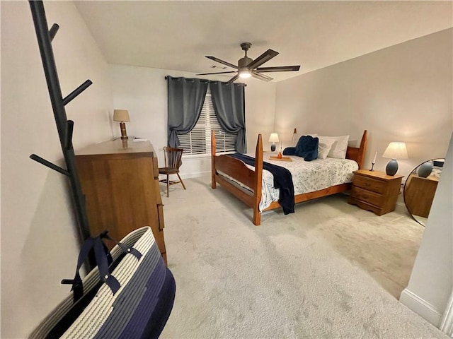 bedroom with light colored carpet, baseboards, and ceiling fan