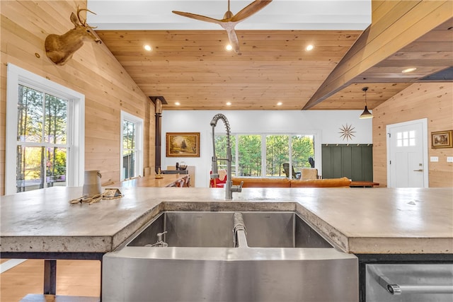 kitchen featuring wood walls, wood ceiling, vaulted ceiling, recessed lighting, and a sink