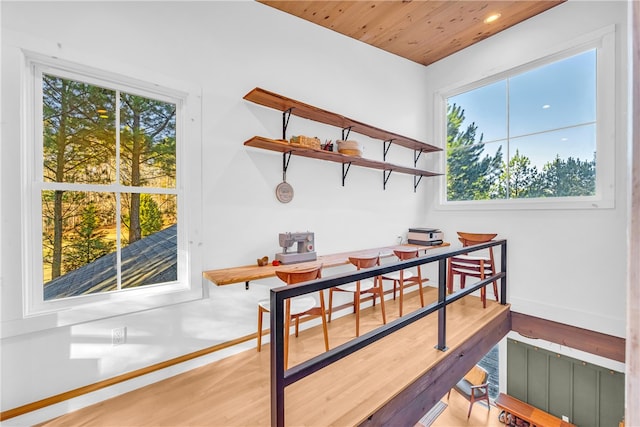 dining room featuring baseboards, wood ceiling, and wood finished floors