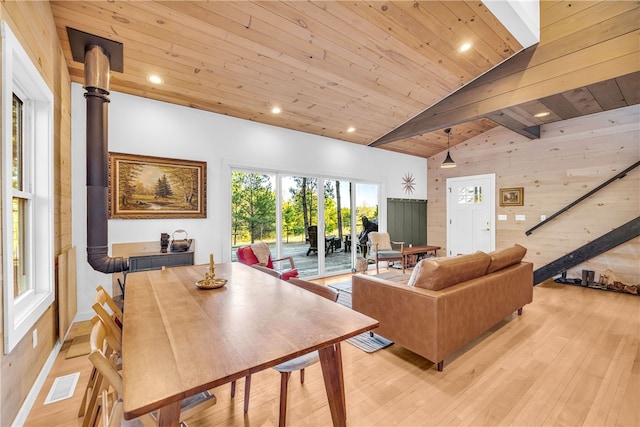 living room featuring visible vents, light wood finished floors, recessed lighting, wood walls, and wooden ceiling