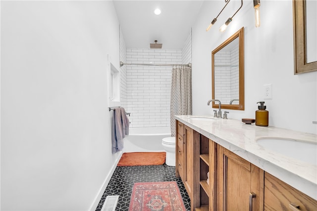 full bath featuring a combined bath / shower with rainfall shower, toilet, a sink, tile patterned flooring, and double vanity