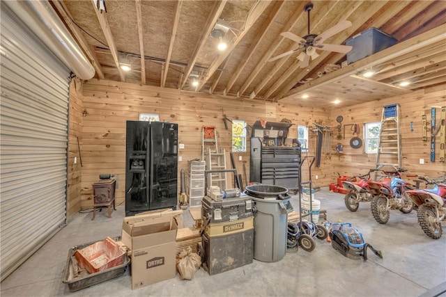 garage featuring wooden walls and a ceiling fan