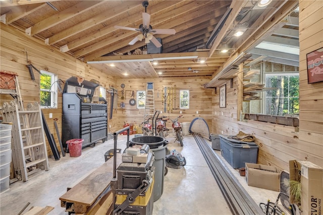 misc room featuring wooden walls, a ceiling fan, and lofted ceiling