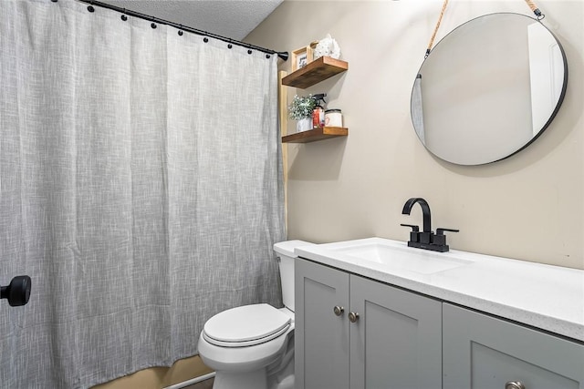 bathroom featuring a textured ceiling, toilet, and vanity