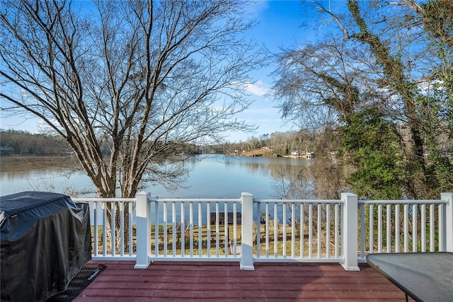 deck with grilling area and a water view