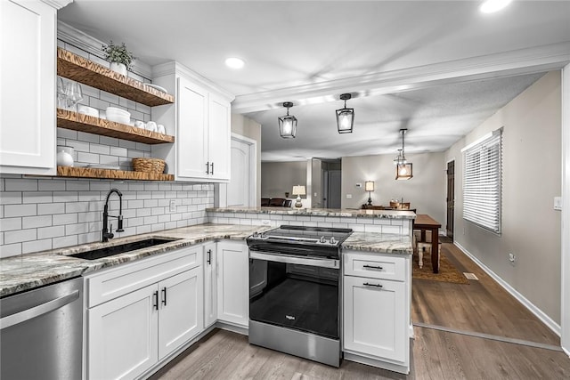 kitchen with a sink, light wood-type flooring, appliances with stainless steel finishes, a peninsula, and open shelves