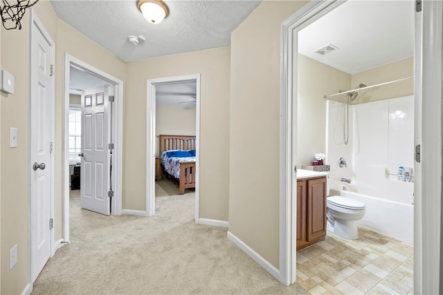 hallway featuring baseboards, light colored carpet, visible vents, and a textured ceiling