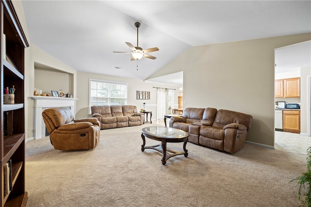 living room featuring visible vents, lofted ceiling, a fireplace, ceiling fan, and carpet flooring