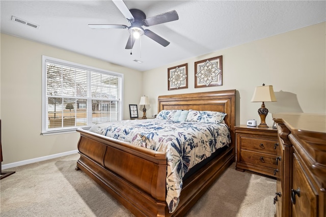 bedroom with visible vents, baseboards, light carpet, a textured ceiling, and a ceiling fan