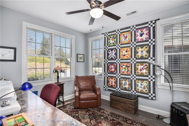 office area with a ceiling fan, wood finished floors, visible vents, and baseboards