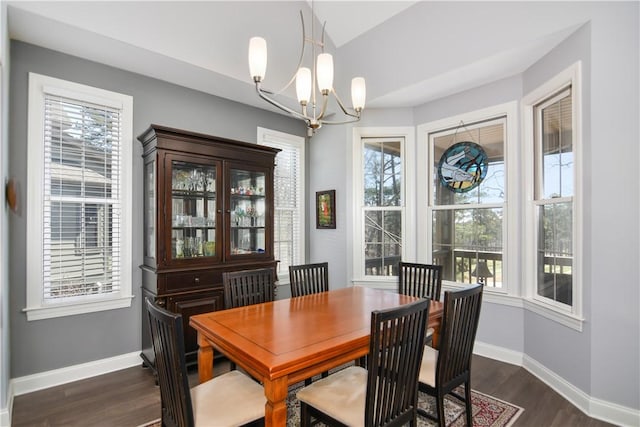 dining area featuring plenty of natural light, baseboards, an inviting chandelier, and dark wood-style flooring