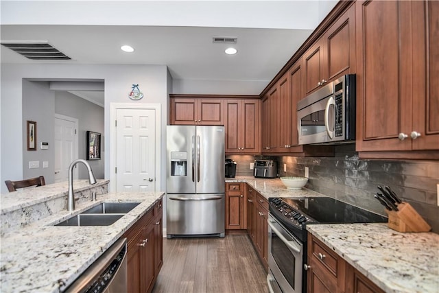 kitchen with visible vents, stainless steel appliances, light wood-style floors, and a sink