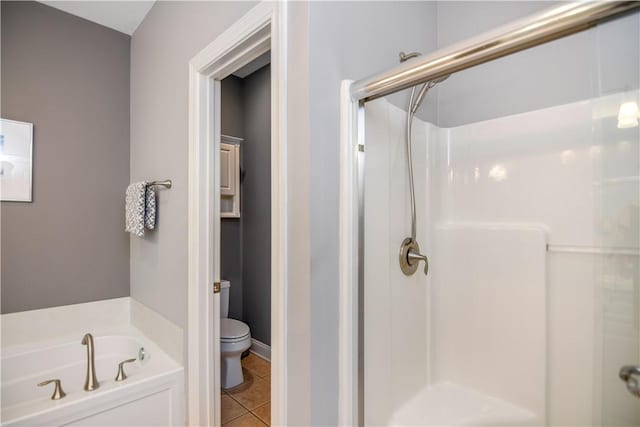 full bathroom featuring tile patterned floors, a shower stall, toilet, and a bath