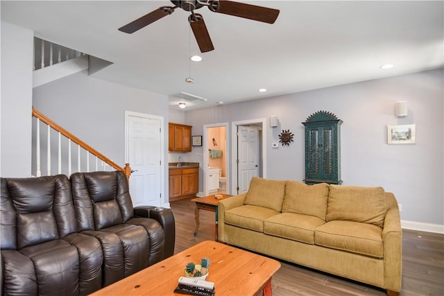 living area with wood finished floors, baseboards, a ceiling fan, recessed lighting, and stairs