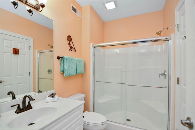 full bathroom with visible vents, toilet, a stall shower, and vanity