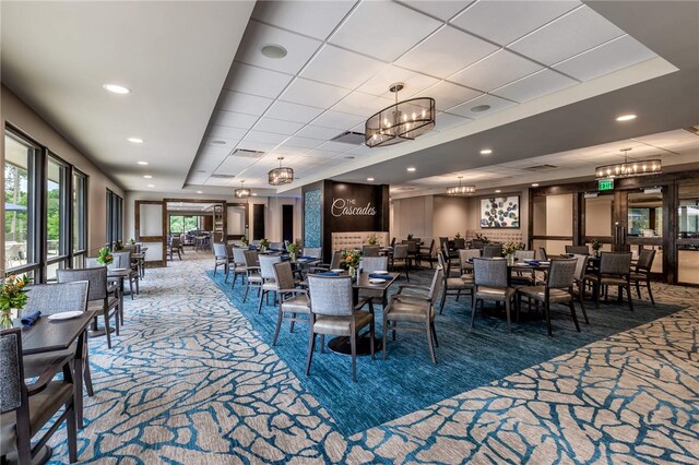 interior space with visible vents, recessed lighting, a tray ceiling, and an inviting chandelier