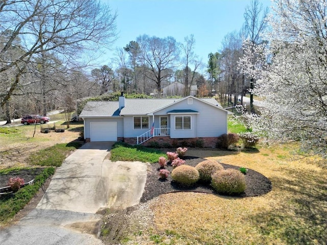 view of front facade with a garage, a front yard, concrete driveway, and a chimney