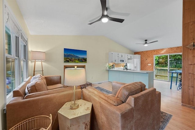 living area with a ceiling fan, light wood-style floors, and lofted ceiling