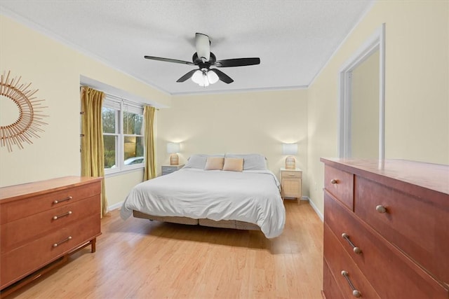 bedroom featuring light wood-style flooring, a ceiling fan, crown molding, and baseboards