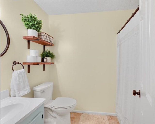 bathroom with tile patterned flooring, toilet, vanity, and baseboards