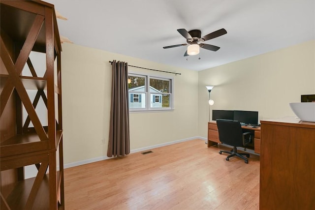 office area with a ceiling fan, light wood-style flooring, baseboards, and visible vents