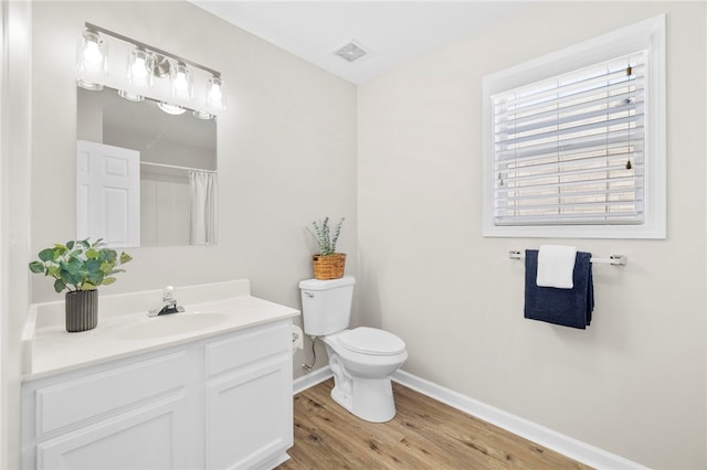 full bath with visible vents, baseboards, toilet, wood finished floors, and vanity