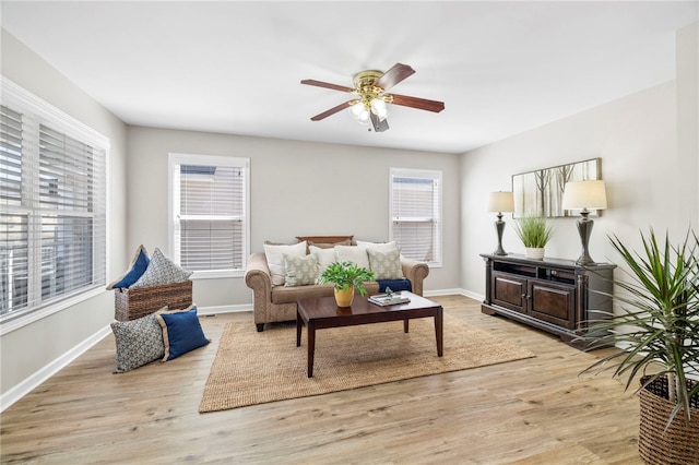 living room with baseboards, light wood-style floors, and ceiling fan