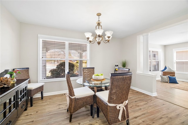 dining room with light wood-style flooring, baseboards, and ornate columns