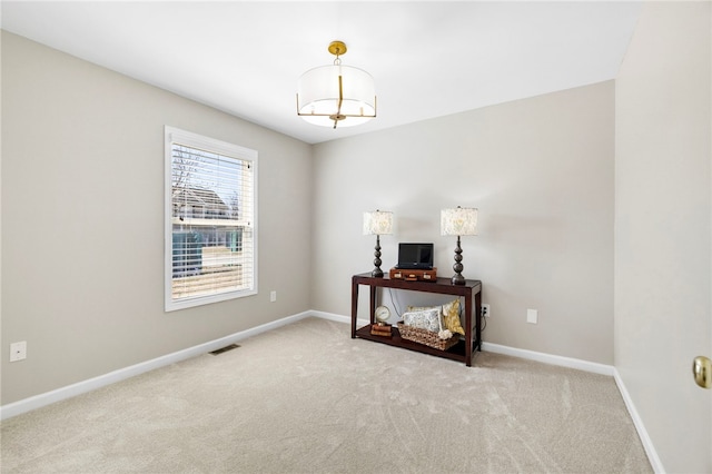 carpeted spare room with visible vents and baseboards