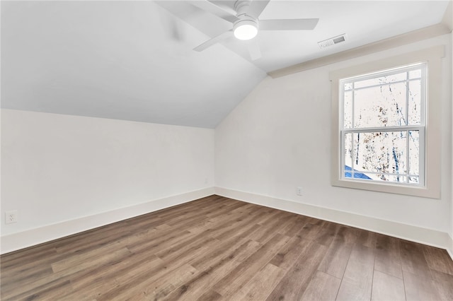 additional living space with visible vents, baseboards, lofted ceiling, and wood finished floors