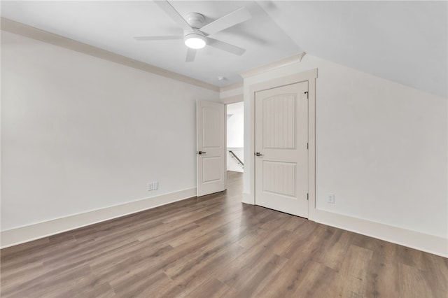 interior space with baseboards, lofted ceiling, wood finished floors, and a ceiling fan